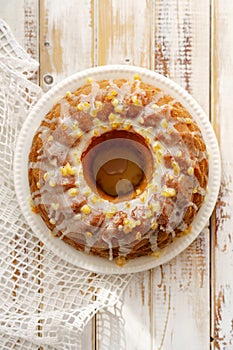 Easter Yeast cake on a white plate on a wooden table, top view.