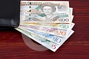 Eastern Caribbean dollars in a black wallet