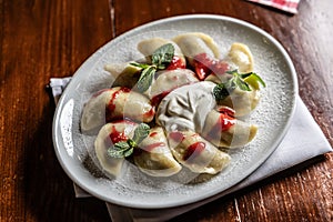 Eastern European traditional food dumplings - pierogi, varenyky, pirohy filled with strawberries and topped with jam
