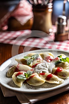 Eastern European traditional food dumplings - pierogi, varenyky, pirohy filled with strawberries and topped with jam
