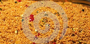 Easy bulgur pilaf pilavi with tomatoes in a ceramic bowl on a dark background close-up. Turkish cuisine, vegan food.