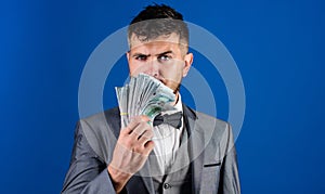 Easy cash loans. Man formal suit hold pile of dollar banknotes blue background. Businessman got cash money. Richness and