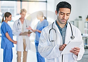 The easy jobs will take care of themselves. a young male doctor standing in a hospital.