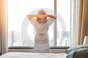 Easy lifestyle Asian woman waking up from good sleep in weekend morning taking some rest, relaxing in comfort bedroom at hotel