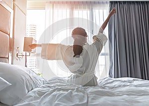 Easy lifestyle Asian woman waking up from good sleep in weekend morning taking some rest, relaxing in comfort bedroom at hotel