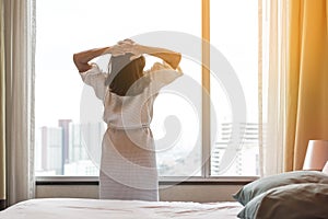 Easy lifestyle Asian woman waking up in the morning taking some rest relaxing in hotel room for world lazy day concept