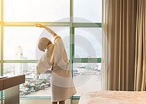 Easy lifestyle Asian woman waking up in weekend morning taking some rest relaxing in comfort city hotel room enjoying world lazy