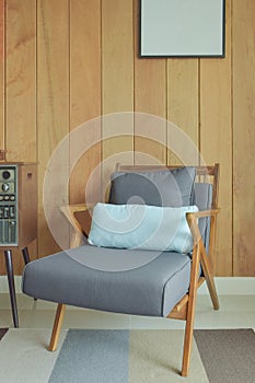 Easy lounge chair with wooden wall background in retro style