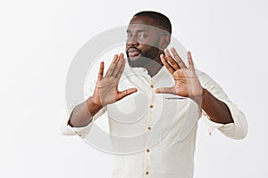 Easy man I got it. Serious-looking calm and confident professional African American businessman in white shirt raising