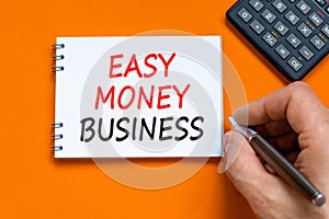 Easy money business symbol. Concept words Easy money business on beautiful white note. Beautiful orange background. Businessman