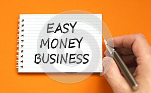 Easy money business symbol. Concept words Easy money business on beautiful white note. Beautiful orange background. Businessman