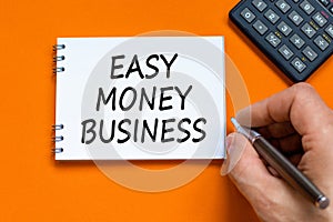 Easy money business symbol. Concept words Easy money business on beautiful white note. Beautiful orange background. Businessman