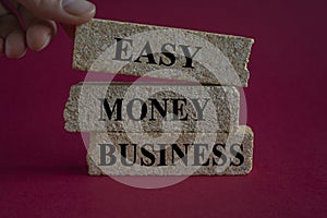 Easy money business symbol. Concept words Easy money business on brick blocks. Beautiful red background. Businessman hand. Easy