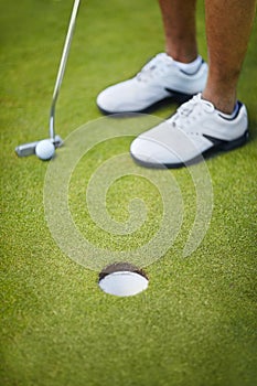 An easy putt. High angle cropped shot of a golfer about to putt a ball in the hole.