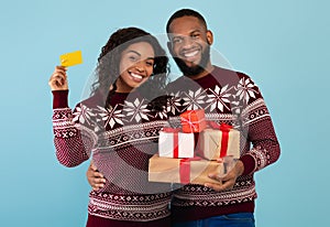 Easy and quick gifts for Christmas with online shopping. Happy african american couple holding gifts and credit card