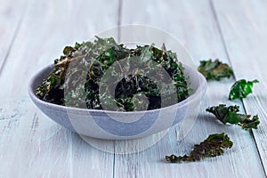 Easy three ingredient baked green kale chips with sea salt and olive oil, in gray bowl, horizontal