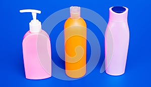 Easy to refill and dispense. Toiletry bottles in row. Refillable bottles blue background