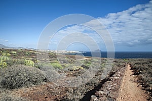 Easy trekking path going down from Montana Amarilla towards Golf del Sur resort and Los Abrigos, Tenerife, Spain photo