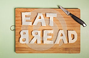 Eat bread text carved out of white bread slices