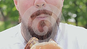 Eat a burger. Close-up male face eating a cheeseburger