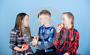 Eat fruit and be healthy. Promoting healthy nutrition. Boy and girls friends eat apple. Teens with healthy snack. Group