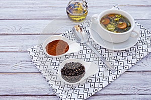 Eat healthy and diet with a fresh, ready-to-eat homemade vegetable soup. Background of a white wooden table, olive oil, spice and