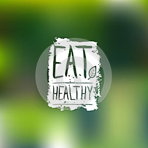 Eat healthy vector logo with hand lettering. Organic food label on blur background for vegan cafe, product packaging.