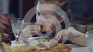 Eat, my little girl. Hand of a woman giving a plate wish meat, vegetables and pasta to an excited little girl. Eating