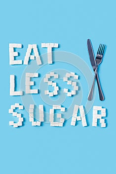 Eat less sugar inscription made of sugar cubes on trendy blue background