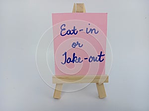 Eat in or take out sign on a wood easel on a white background