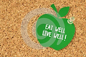 Eat well, Live well! written on apple shaped paper note on pinboard photo