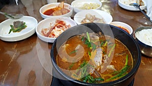 Eating boiling blood suasage red soup with pig's ear local Korean food soondae hot stew slowmotion