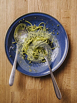 Eating a bowl of pasta spaghetti with pesto sauce