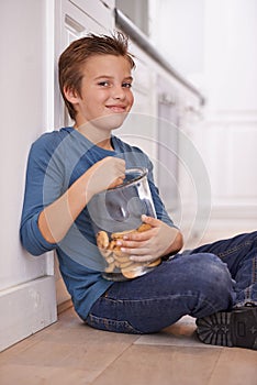 Eating, cookies and portrait of child in home with glass, container or happy with jar of sweets on floor. House, kitchen
