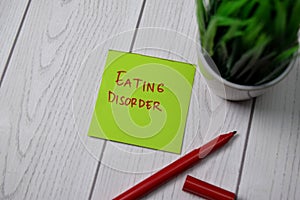 Eating Disorder write on sticky note isolated on wooden table