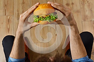 Eating Fast Food. Hands Holding Hamburger. Point Of View. Nutrition