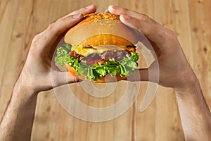 Eating Fast Food. Hands Holding Hamburger. Point Of View. Nutrition