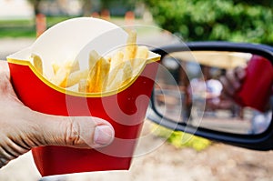 Eating fast food. Man hands holding McDonalds French Fries outdo