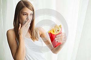 Eating Food. Funny pretty young woman with fries