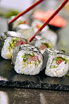 Eating Fresh Vegetarian Sushi Rolls or Veggie Roll with Chopsticks