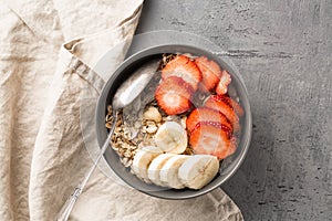 Eating healthy breakfast bowl. Muesli and fresh fruits in ceramic bowl. Clean eating, dieting, detox, vegetarian food concept.