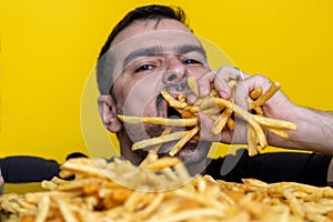 Eating junk food nutrition and dietary health problem concept. Young man eating with two hands a huge amount of unhealthy fast