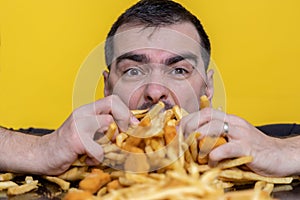 Eating junk food nutrition and dietary health problem concept. Young man eating with two hands a huge amount of unhealthy fast