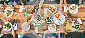 Eating and leisure concept - group of people having dinner at table with food photo