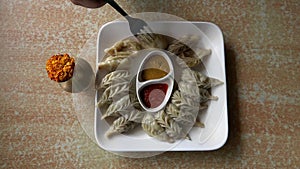 Eating Nepalese Traditional Dish Momo. Authentic Cuisine in Nepal