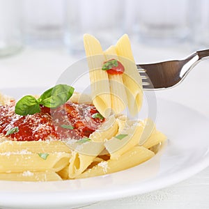 Eating pasta Rigate Napoli with tomato sauce with fork photo