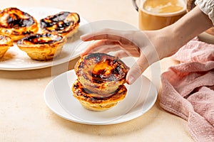 Eating pastel de nata or pastel de Belem, Portuguese baked egg custard tart pastry