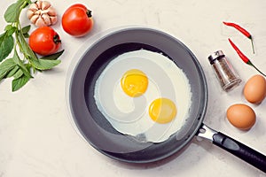 Eating in the process, fried eggs in a frying pan for breakfast