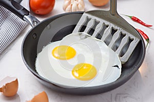 Eating in the process, fried eggs in a frying pan for breakfast