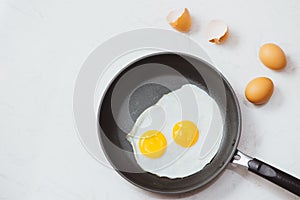 Eating in the process, fried eggs in a frying pan for breakfast on a white background. Daylight